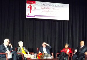 Photo shows a panel of five people on a stage under a banner that announces the CAEL conference.