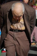 an elderly Asian man walking