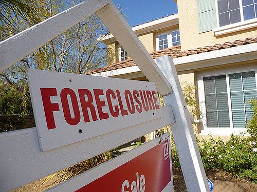 house with foreclosure sign in front