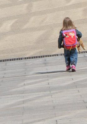 small child with backpack and teddy bear